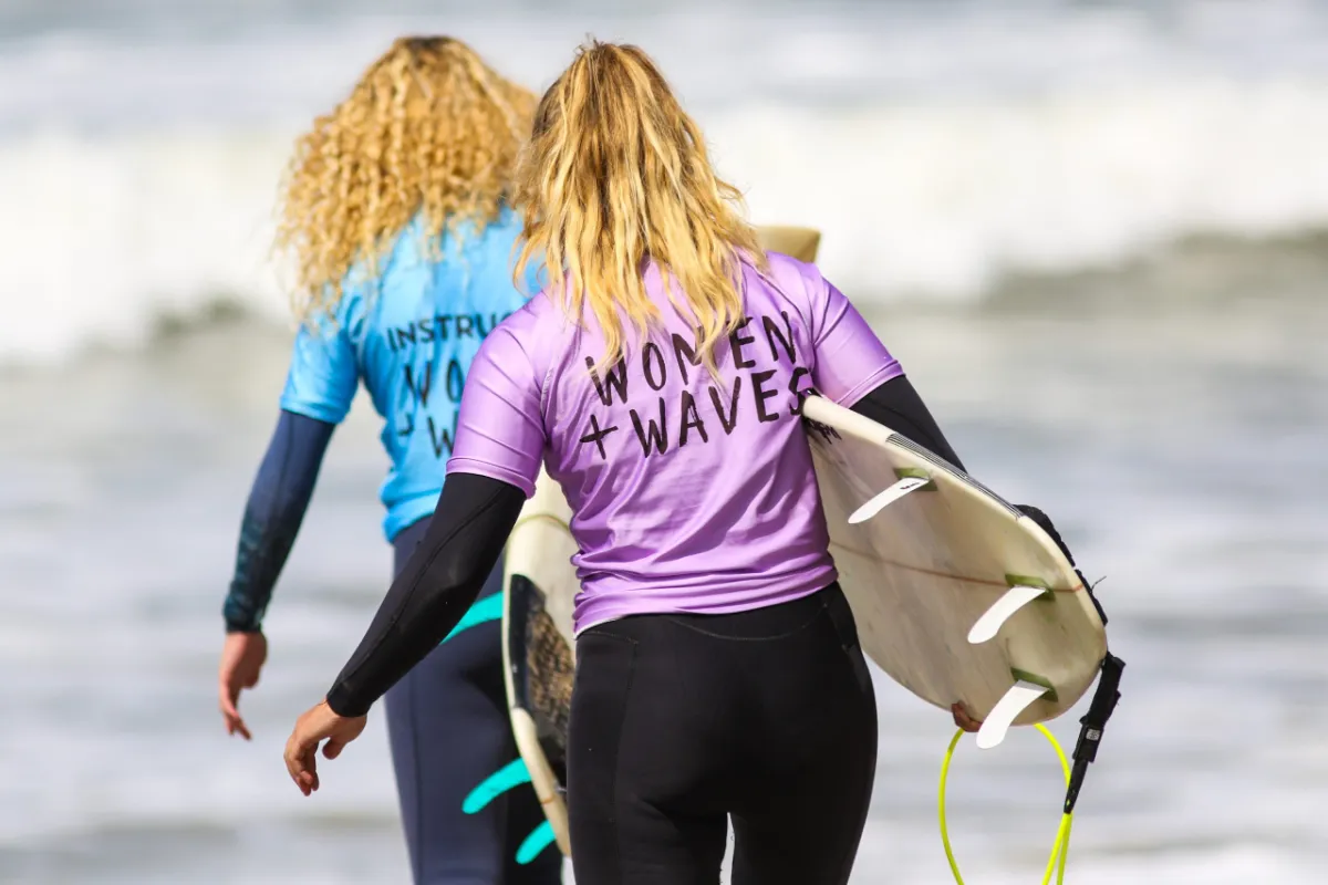 Surfers carrying a board