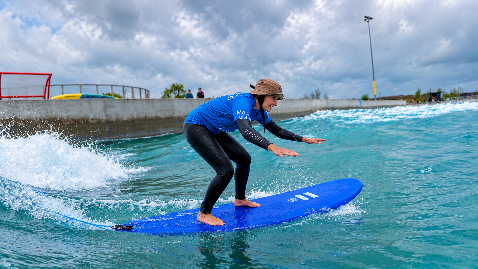 Woman surfing on an artificial wave at The Wave surf park