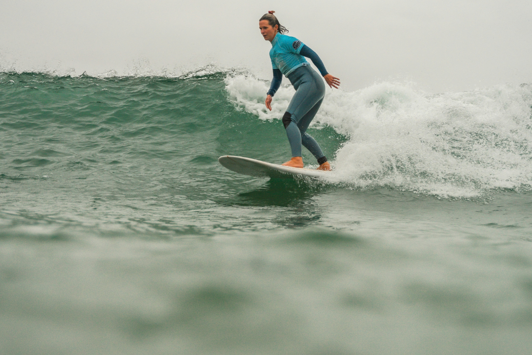 Woman surfing on a wave in overcast conditions