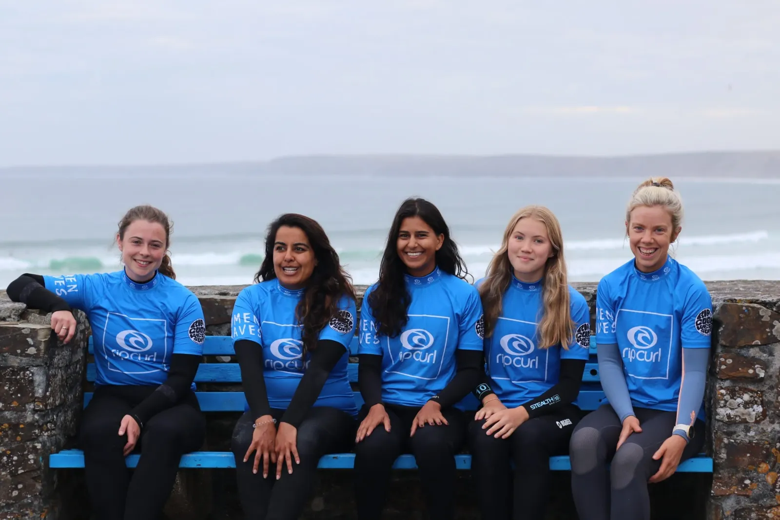 Group of surfers sat by beach