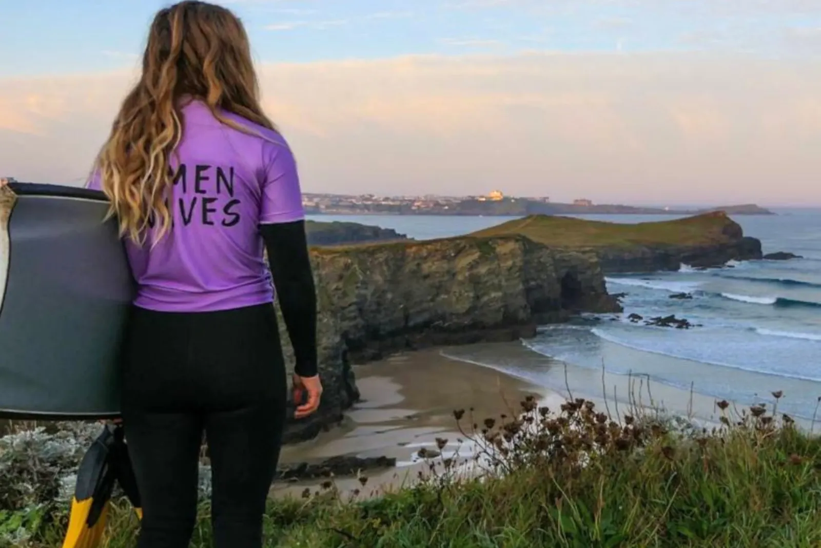 Female bodyboard standing on a cliff