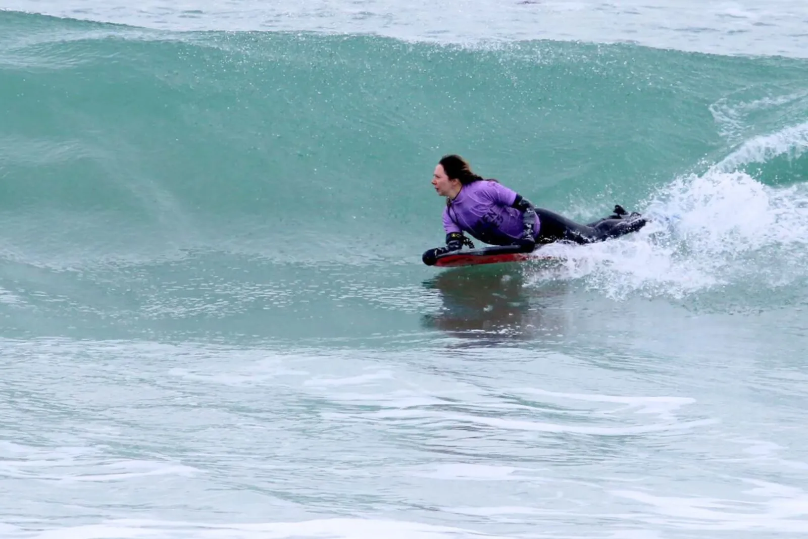 Lady on a bodyboard riding a wave